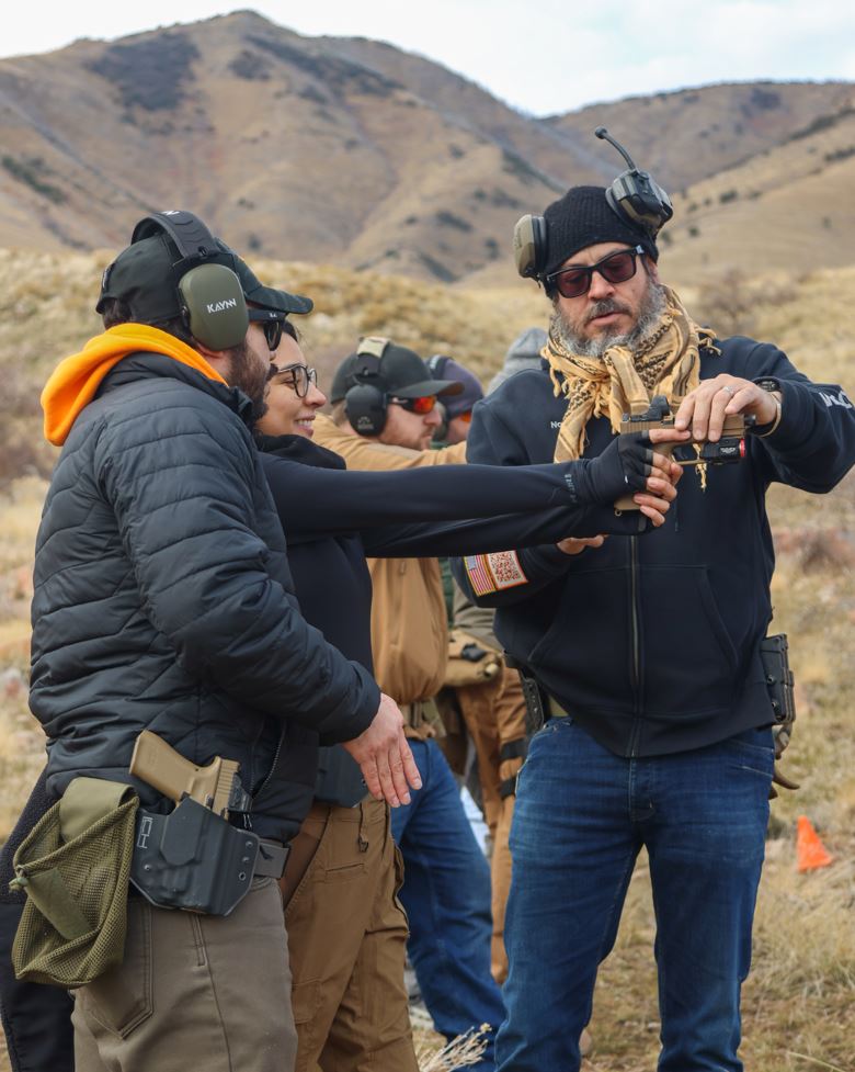 NTAC instructor correcting student grip at outdoor firearms course