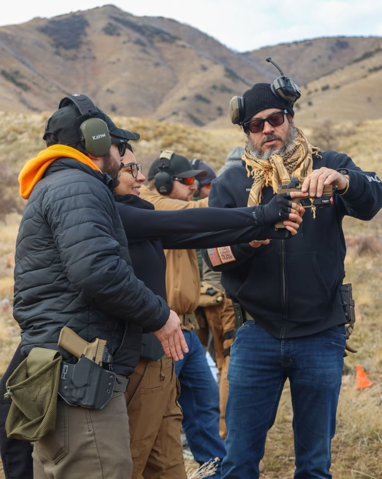 Firearms instructor leading defensive handgun training course