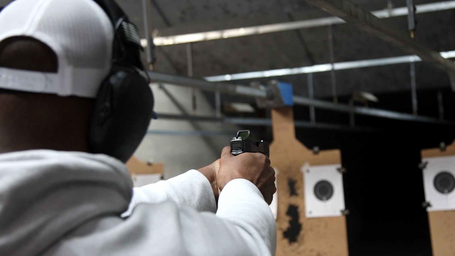 Student shooting pistol at indoor range during Nielsen Training course
